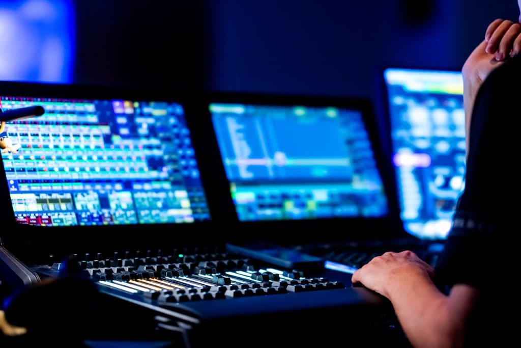 Close-up of a sound engineer working on a professional audio mixing console.